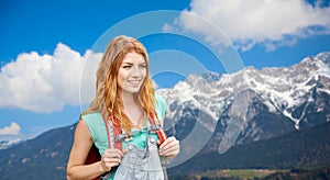 Smiling woman with backpack over alps mountains