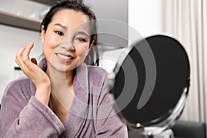 Smiling Woman in Bathrobe Enjoying Skin Care Routine