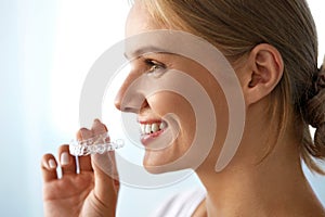 Smiling Woman With Beautiful Smile Using Invisible Teeth Trainer photo