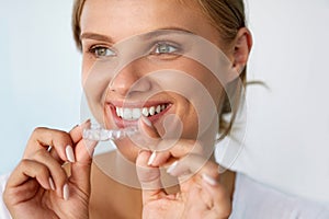 Smiling Woman With Beautiful Smile Using Teeth Whitening Tray photo