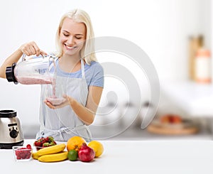 Smiling woman with blender and fruit milk shake