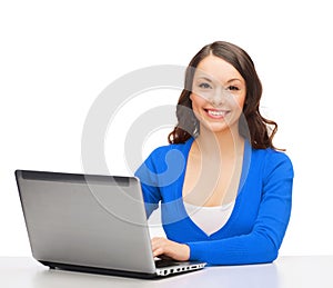 Smiling woman in blue clothes with laptop computer