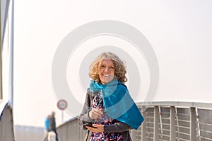 Smiling woman in blue scarf on the bridge