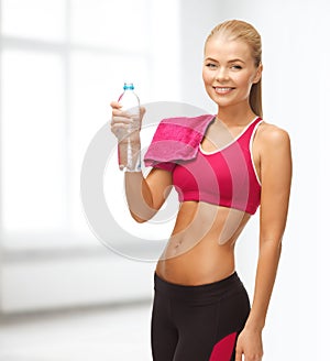 Smiling woman with bottle of water and towel