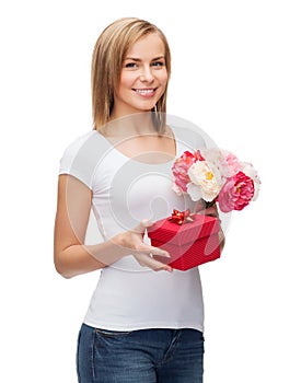 Smiling woman with bouquet of flowers and gift box