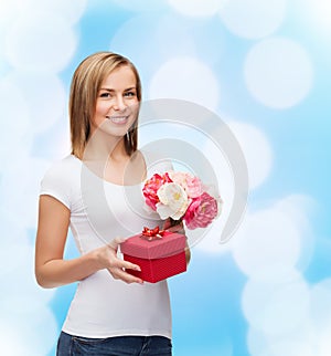 Smiling woman with bouquet of flowers and gift box