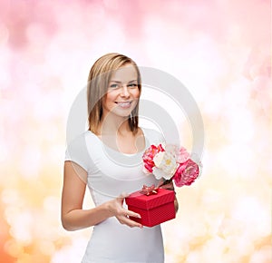 Smiling woman with bouquet of flowers and gift box