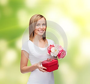 Smiling woman with bouquet of flowers and gift box