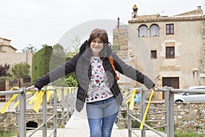 Smiling woman on a bridge full of yellow ties, Monells, Girona, Catalonia, Spain photo