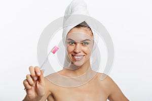 Smiling woman brushing her teeth with towel on her head. A great smile