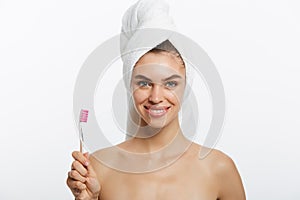 Smiling woman brushing her teeth with towel on her head. A great smile