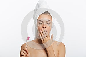 Smiling woman brushing her teeth with towel on her head. A great smile