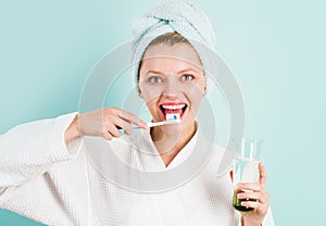Smiling Woman brushing teeth with Toothpaste and toothbrush in bathroom. Dental higiene. Ceaning teeth. photo