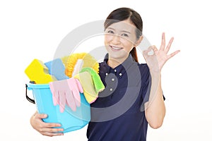 A smiling woman with a bucket