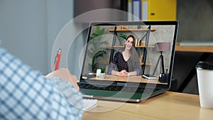 Smiling woman business coach in computer screen greets talk teaches student