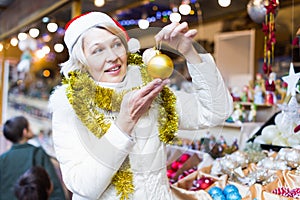 Smiling woman is buying toys for X-mas tree in the market