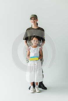 Smiling woman in camouflage uniform hugging