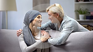 Smiling woman with cancer hugging mother, hope and togetherness, remission