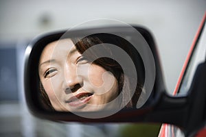 Smiling woman in car mirror