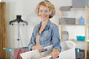 smiling woman carrying laundry basket