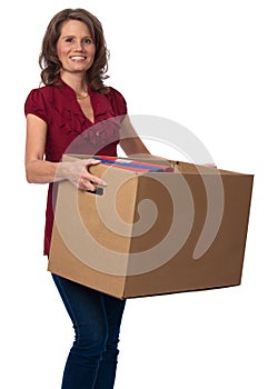Smiling woman carrying moving box with binders