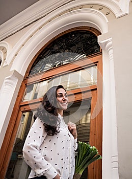 Smiling woman carrying shopping bag while walking down the street. Beautiful young woman with healthy shopping in an