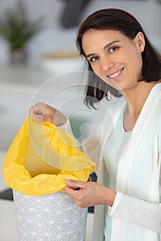smiling woman changing garbage bags