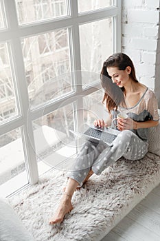 Smiling woman chatting on laptop