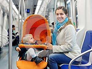 Smiling woman with child in subway train