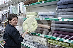 A smiling woman chooses goods in a pet store. Retail trade. Consumerism