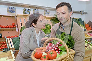 smiling woman choosing different fruits at farm food store display photo