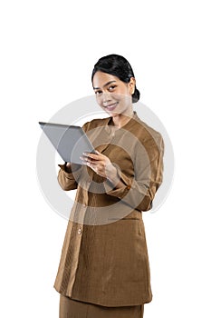 Smiling woman in civil servant uniform standing using a digital tablet