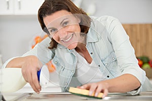 smiling woman cleaing kitchen sink