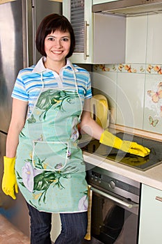 Smiling woman cleaning cooker