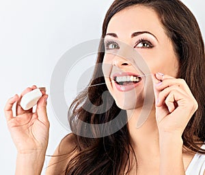 Smiling woman cleaning the teeth the dental floss on blue background with empty space. Dental Hygiene. Closeup