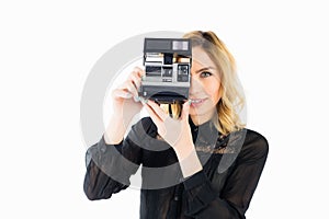 Smiling woman clicking photo from camera against white background