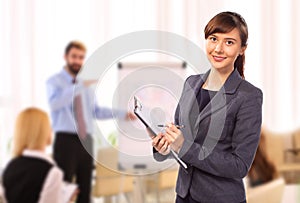 Smiling woman with clipboard in office