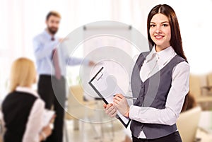 Smiling woman with clipboard in office