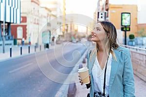 Smiling woman with coffee to go in city