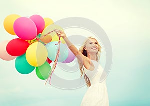 Smiling woman with colorful balloons outside