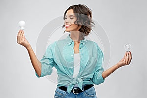 Smiling woman comparing different light bulbs