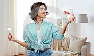 Smiling woman comparing different light bulbs