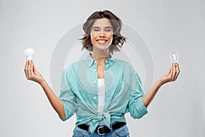 Smiling woman comparing different light bulbs