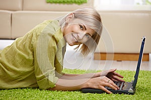 Smiling woman with computer at home