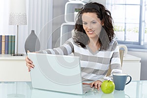 Smiling woman with computer at home