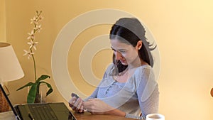 Smiling woman at computer sending a text message