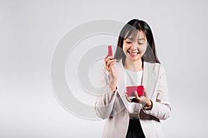 Smiling woman confidence opening a red gift box on palm isolated white background