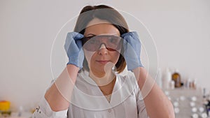 Smiling woman cosmetician in safety glasses