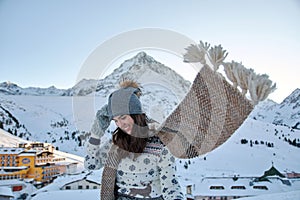 Smiling woman in a cozy sweater and scarf at the Kuhtai ski resort in Otztal, Austria