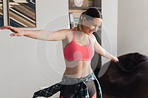 Smiling woman dancing in the middle of the living room enjoying herself and life